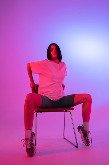 Full shot young woman posing on chair