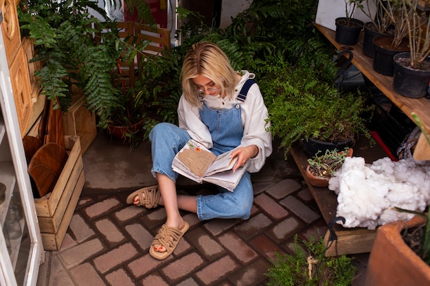 Free photo full shot young woman surrounded by plants