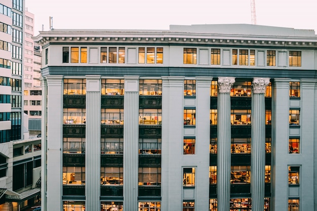 Free Photo full view of a modern white building with columns and engravings on them with windows and lights