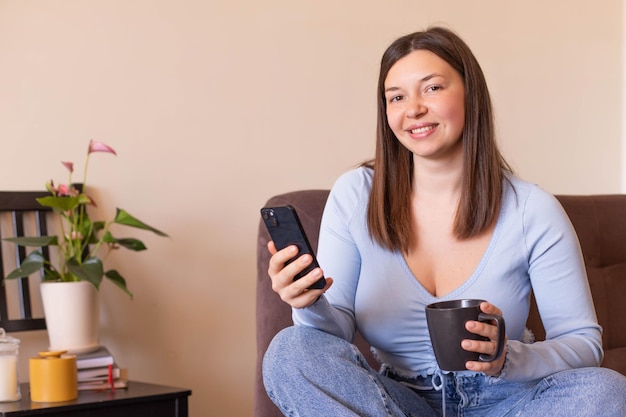 Full view of woman sitting at home look and smile at camera