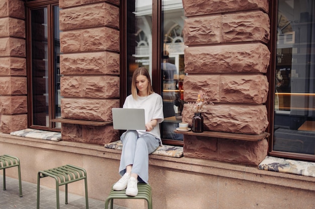 Fulllength view of beautiful woman in cafe working on laptop