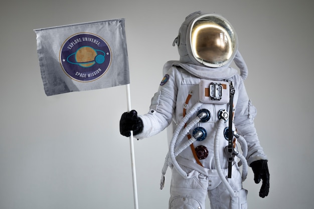 Free photo fully equipped male astronaut holding a flag