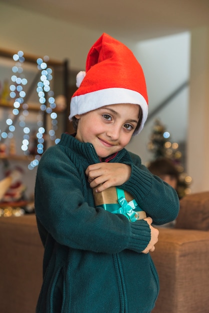 Free photo funny boy in christmas hat with present box