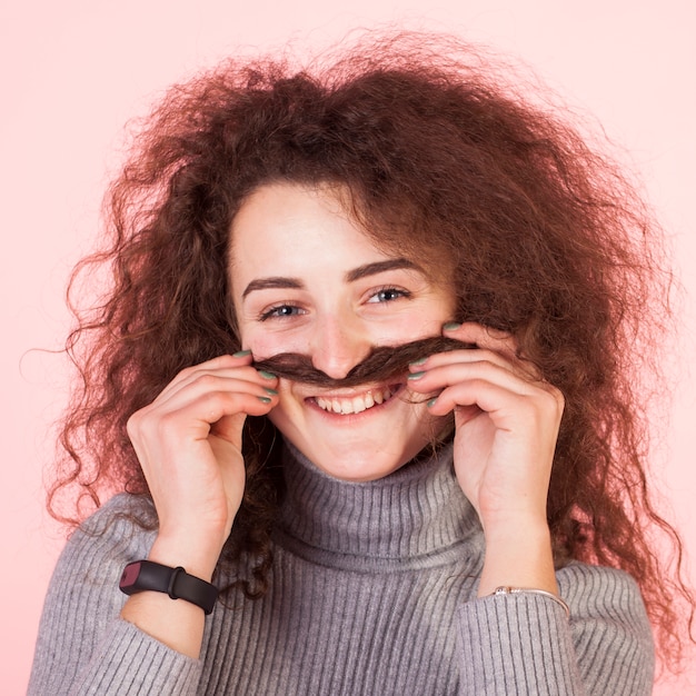 Funny brunette girl portrait on pink background