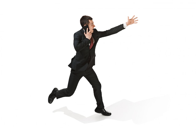 Free photo funny cheerful businessman running and talking on the phone