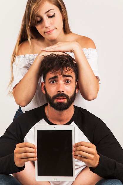 Funny couple holding tablet