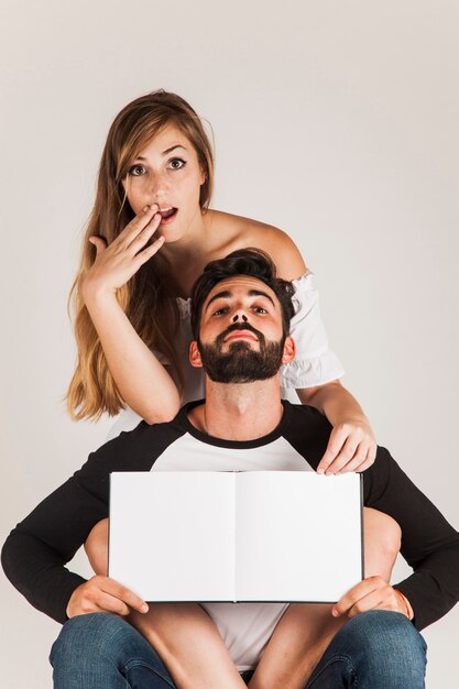 Funny couple showing blank book