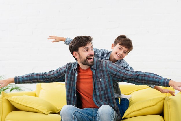 Funny father and son playing on sofa