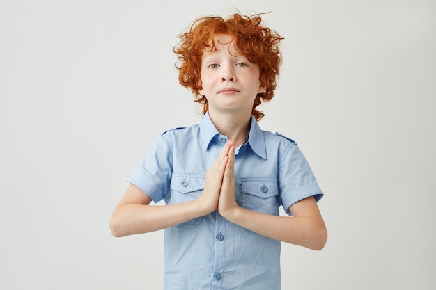 Free photo funny ginger boy with sad and guilty face expression trying apologizes