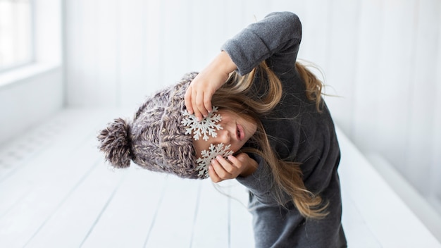 Free photo funny girl covering her eyes with snowflakes