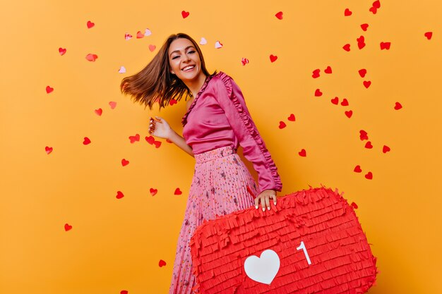 Funny girl in pink blouse dancing. Amazing caucasian model enjoying portraitshoot with confetti.