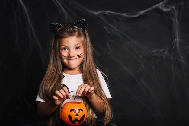 Free photo funny girl with cat ears and trick or treat bucket