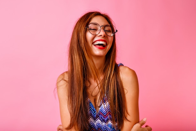 Funny stylish beautiful brunette woman having fun and dancing at pink wall