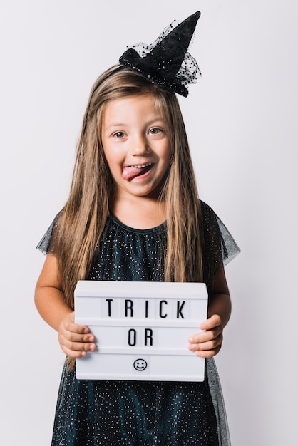 Free photo funny witch holding board with writing