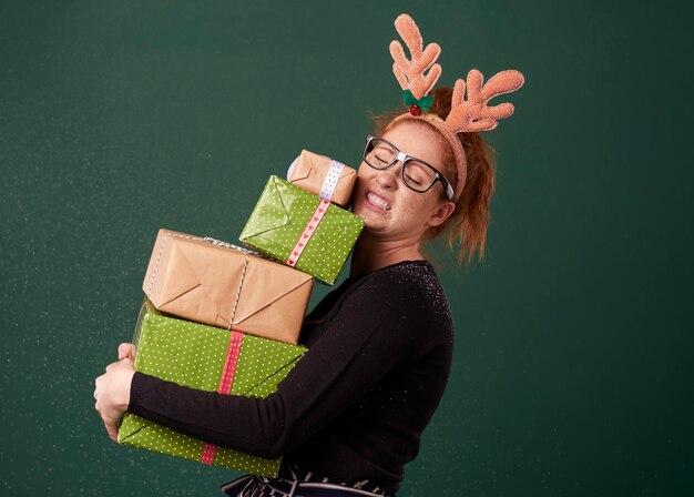 Free Photo funny woman carrying stack of heavy christmas gifts