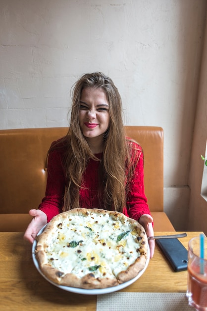 Free photo funny woman showing her pizza