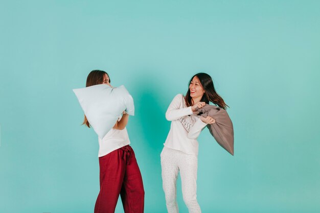 Funny women having pillow fight