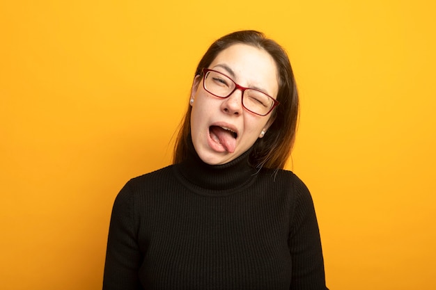 Free Photo funny young beautiful girl in a black turtleneck winking sticking out tongue happy and positive 