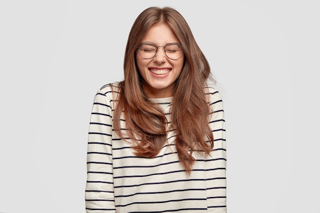 Free photo funny young woman with glasses posing against the white wall