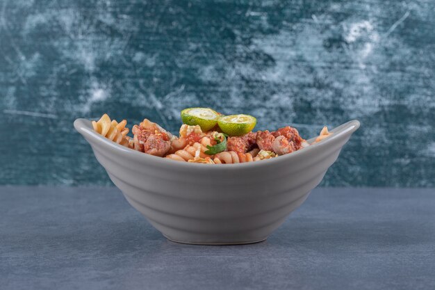 Fusilli pasta with chicken in ceramic bowl.