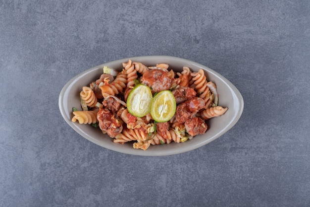 Fusilli pasta with chicken in ceramic bowl.