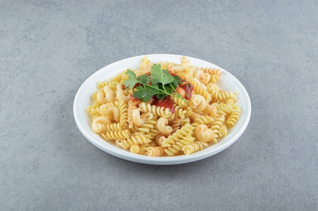 Free photo fusilli pasta with sauce on white plate.