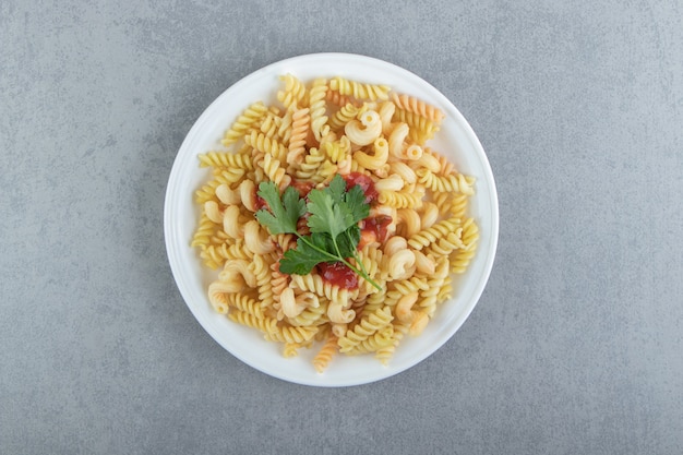 Fusilli pasta with sauce on white plate.