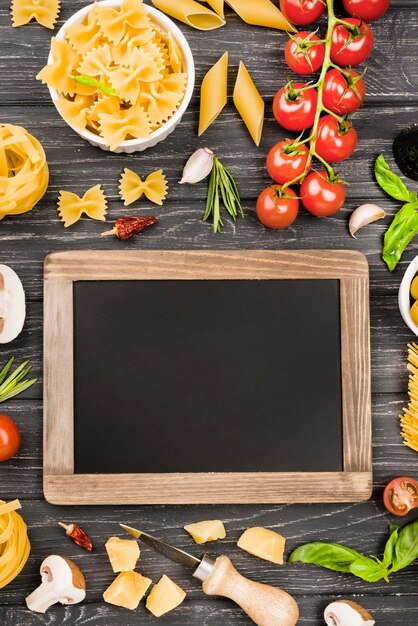 Fusilli with vegetables ingredients and chalkboard