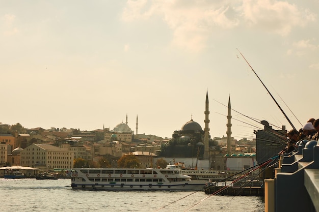 Galata Bridge with fishermen in Istanbul with a view of the city and ship