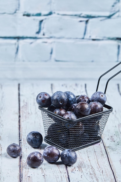 Free photo garden plums on blue table.