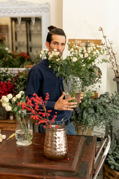 Gardener holding a big vase of leaves and flowers