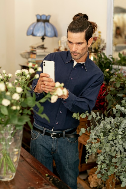 Gardener man with long hair taking a photo