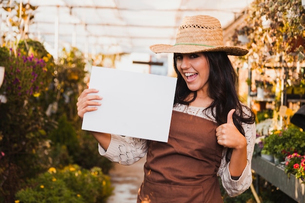 Gardener with paper sheet gesturing thumb-up