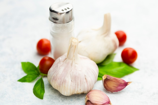 Free photo garlic and cherry tomatoes with salt shaker