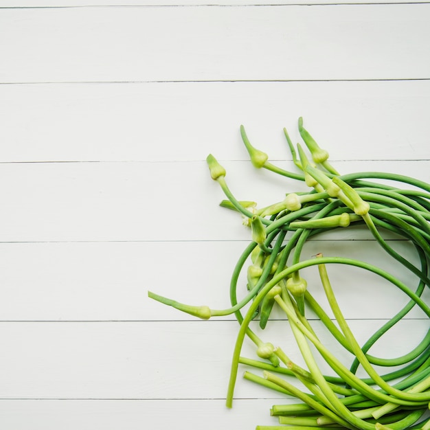 Free photo garlic scape on white wooden table