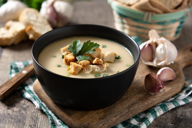 Free photo garlic soup topped with croutons in bowl on wooden table