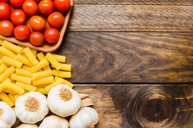 Garlic and tomatoes near pasta