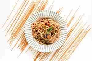 Free photo garnish spaghetti pasta with raw pasta on white surface