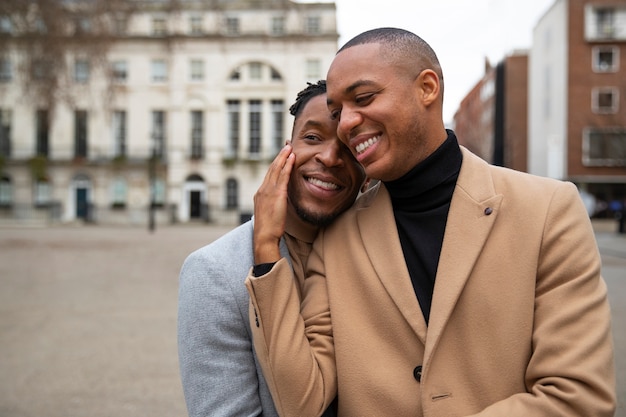 Free photo gay couple being affectionate outdoors in the city