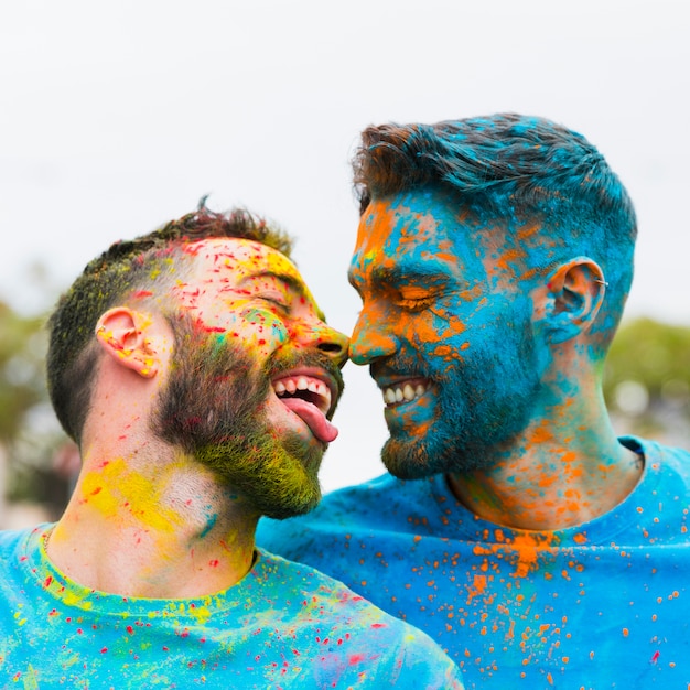 Free photo gay having fun and kissing on holi festival