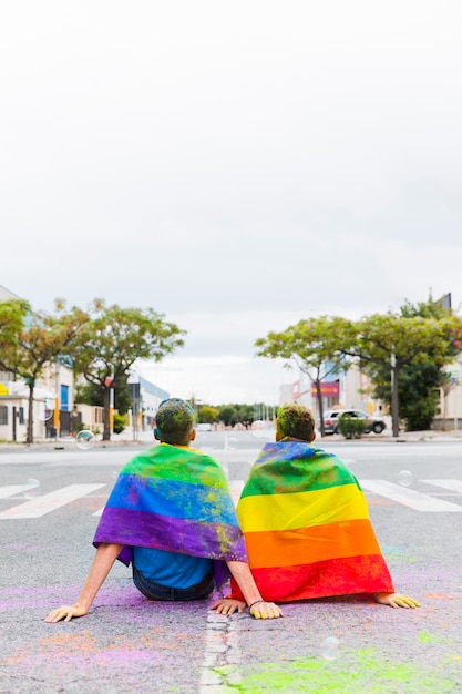 Free Photo gay with rainbow flags sitting on street