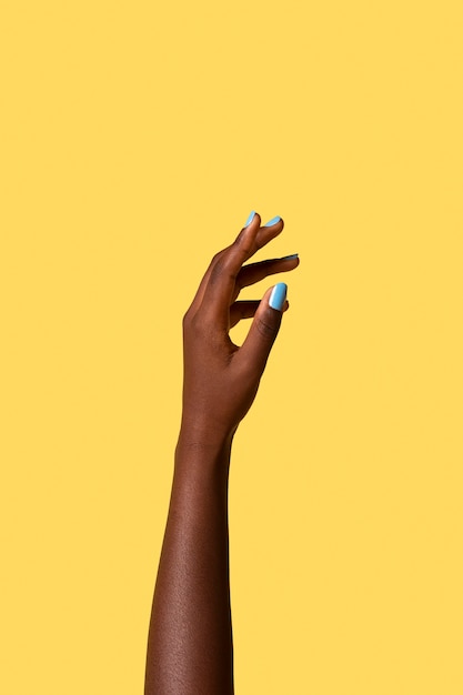 Gender fluid person hand isolated on yellow