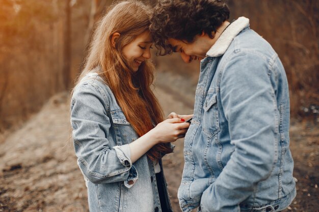 gentle and stylish couple are having a walk in the autumn park