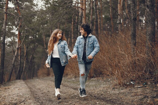 gentle and stylish couple are having a walk in the autumn park