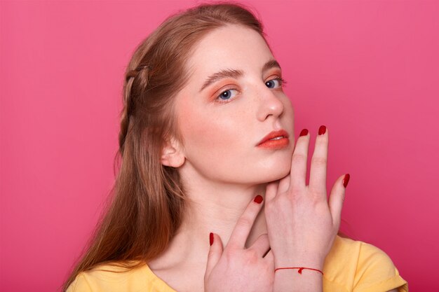 Gentle woman with bright makeup, straight hair with red shade