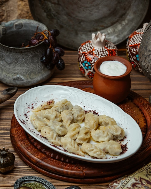 Free photo georgian khinkali inside white plate with yogurt.