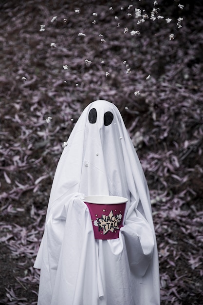 Free Photo ghost holding popcorn box with popcorn in air 