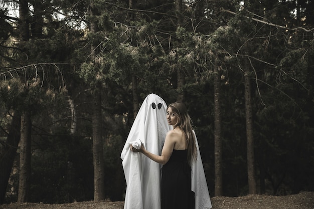 Free photo ghost and lady holding hands in park