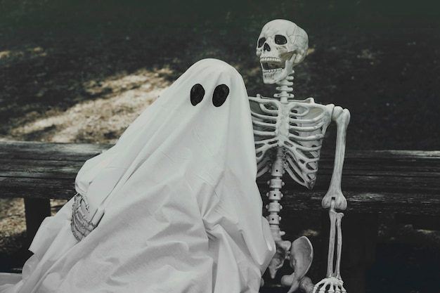 Free Photo ghost and skeleton hugging on bench 