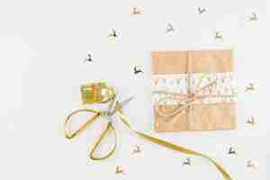 Free photo gift box in craft paper near scissors and ribbon